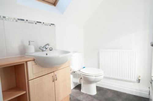 a bathroom with a white toilet and a sink at The Voyager - Newly Furnished Home in Derby
