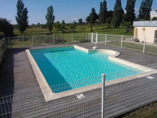 een zwembad met een hek eromheen bij Gites Gayet in Saint-Androny