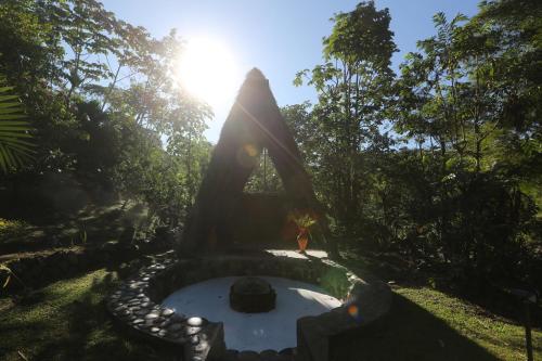 a small pond in a garden with the sun shining at Kuyana Amazon Lodge in Archidona