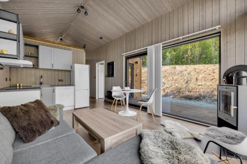 a kitchen and living room with a couch and a table at Målselv Fjellandsby - Cabins in Bardufoss