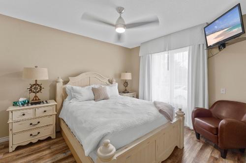 a bedroom with a bed and a tv and a chair at Lakeshore Inn in Cold Lake