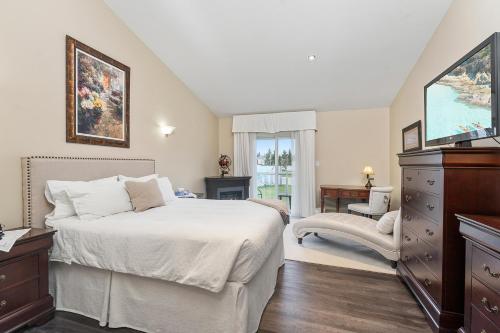 a bedroom with a bed and a dresser and a window at Lakeshore Inn in Cold Lake