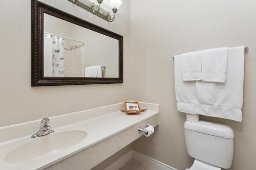 a white bathroom with a sink and a mirror at Lakeshore Inn in Cold Lake