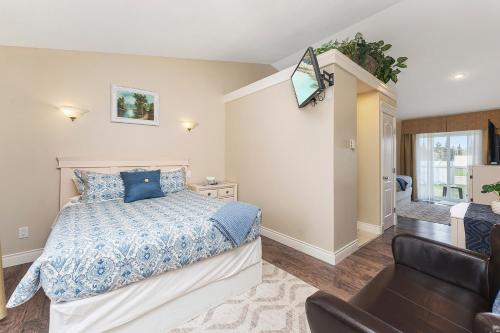 a bedroom with a bed and a chair in it at Lakeshore Inn in Cold Lake