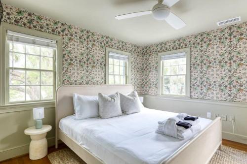 a bedroom with a white bed with floral wallpaper at The Ashley Carriage House Suite Includes Breakfast in Charleston