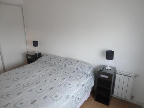 a bedroom with a bed and two night stands at Marco Polo Platinum Apartamento in Mar del Plata