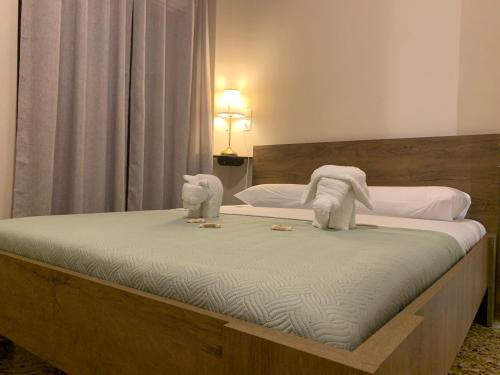 a bed with two stuffed animals on top of it at Rigas Apartment in Artemida