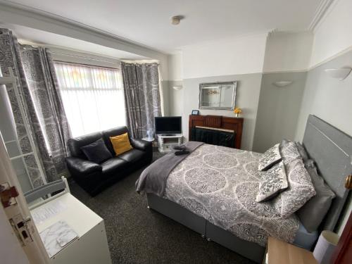 a bedroom with a bed and a couch and a chair at Crumlin Road Town House in Belfast