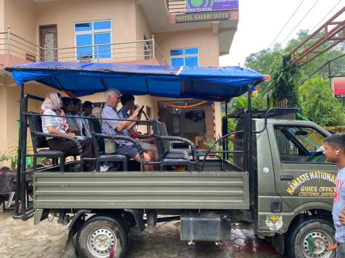 a group of people riding in the back of a truck at Hotel Safari Suite in Sauraha