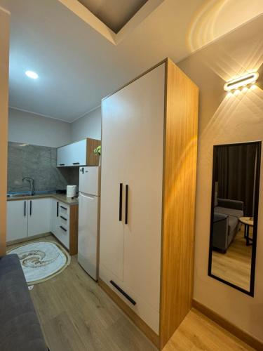 una piccola cucina con un frigorifero bianco e una cucina di Oni Apartment a Tirana