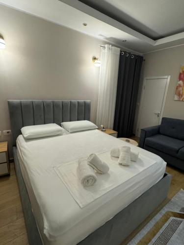 una camera da letto con un grande letto bianco con asciugamani sopra di Oni Apartment a Tirana