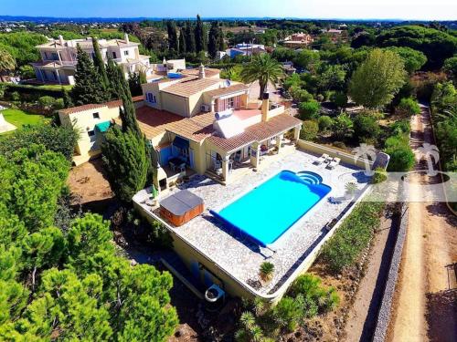 an aerial view of a house with a swimming pool at Peaceful villa with sea view close to Carvoeiro in Carvoeiro