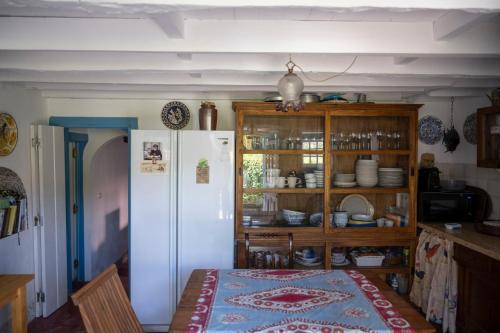 a kitchen with a table and a white refrigerator at New Family Country House in Colares