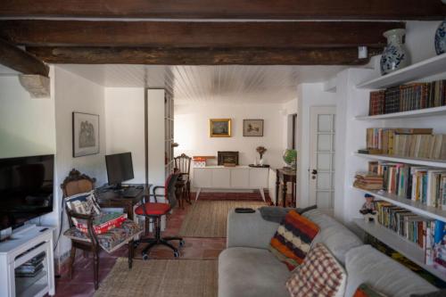 a living room with a couch and a table with a tv at New Family Country House in Colares