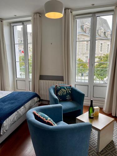 une chambre avec un lit, un canapé et une chaise dans l'établissement Le balcon de la place, à Dinan