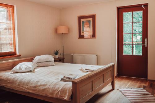 een slaapkamer met een groot bed met witte lakens bij Veskivee Külalistemaja in Umbusi