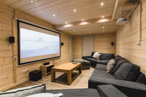 a living room with a large screen in a house at Chalet Matterhorn in Mussillon