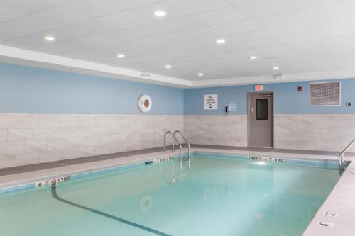 a large swimming pool in a room with blue walls at Holiday Inn Express Hartford-Newington by IHG in Newington
