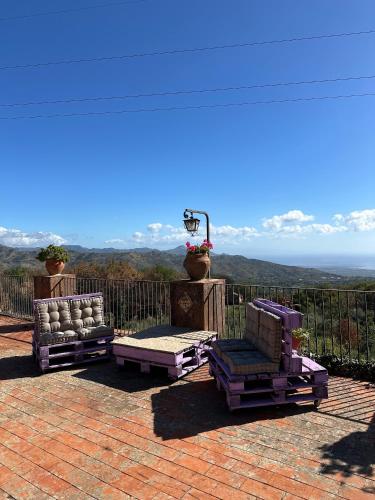 two chairs sitting on a patio with a view of the mountains at Tenuta Reganati in Piedimonte Etneo