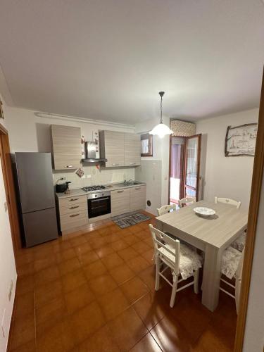 a kitchen with a table and a kitchen with a refrigerator at Casa Vacanze Diva in Rosignano Solvay