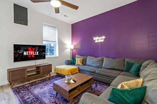 a living room with a couch and a tv at Soulard 4 Bedroom Retreat Near Downtown with Patio and Parking in Soulard