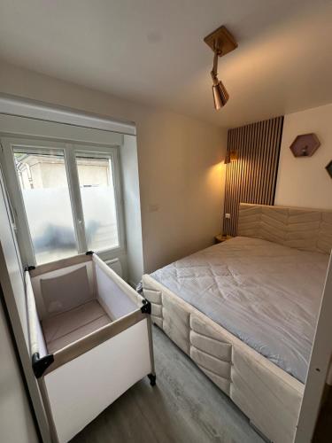 une petite chambre avec un lit et une fenêtre dans l'établissement vshome logement cosy 5min gare RER entre Disneyland et Paris, à Roissy-en-Brie
