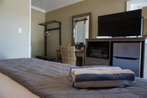 a bedroom with a bed and a flat screen tv at Bleu Beach Resort in Indialantic