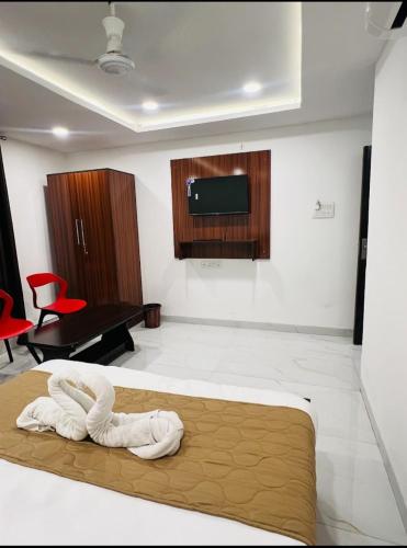 a bedroom with a large bed with a flat screen tv at Hotel Shiv in Indore