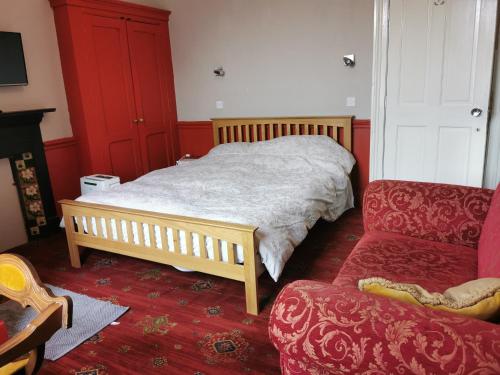 a bedroom with a bed and a couch and a chair at 114 Coltman Street Hull in Hull
