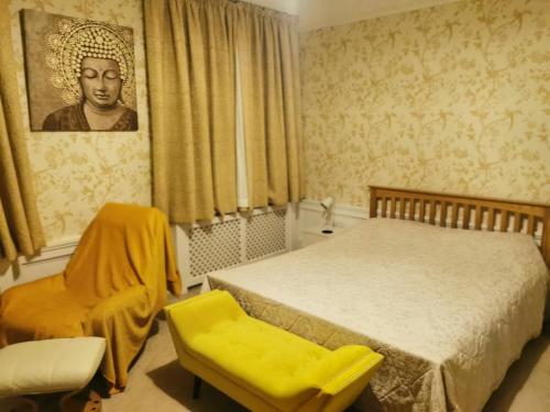 a bedroom with a bed and a yellow chair at 114 Coltman Street Hull in Hull