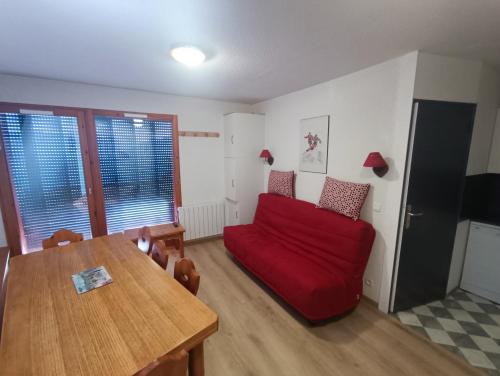 a living room with a red couch and a table at Appartement Le Corbier, 3 pieces, 7 personnes, au pied des pistes in Villarembert