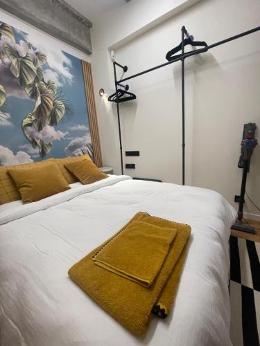 - une chambre avec un lit et des serviettes jaunes dans l'établissement Le Loft Bleu La Madeleine - un mini loft design et très central, à Paris