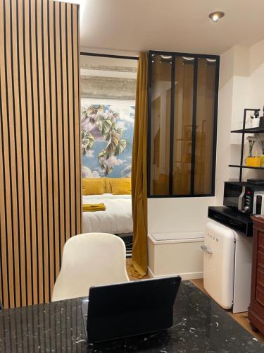 - une chambre avec un lit et un ordinateur portable sur un bureau dans l'établissement Le Loft Bleu La Madeleine - un mini loft design et très central, à Paris