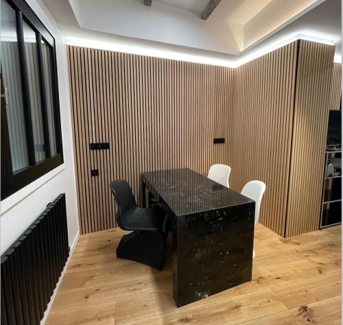 - une table et des chaises noires dans la chambre dans l'établissement Le Loft Bleu La Madeleine - un mini loft design et très central, à Paris