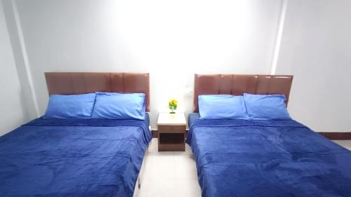 two beds sitting next to each other in a room at Apartment near Central Festival Hatyai in Hat Yai