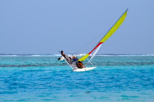 a person riding a wind sail on the ocean at Coquillage Inn in Gulhi