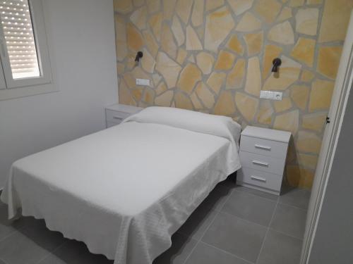 a bedroom with two beds and a stone wall at LA ERA 30 in Bolonia