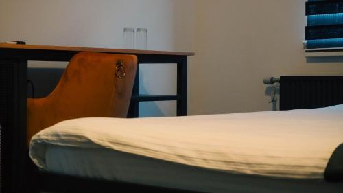 a bedroom with a bed and a wooden desk at IB Oil doo Restoran s prenoćištem in Cazin