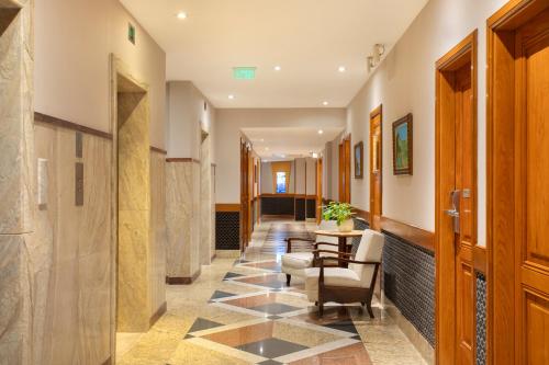 a hallway with a table and chairs in a building at Windsor Guanabara Hotel in Rio de Janeiro