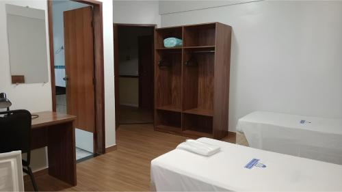 a room with a bed and a desk and a mirror at Nobile Plaza Hotel in Taguatinga