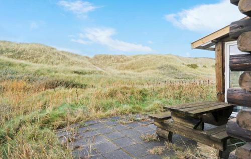 a wooden bench sitting outside of a cabin at Nice Home In Harboøre With Kitchen in Harboør