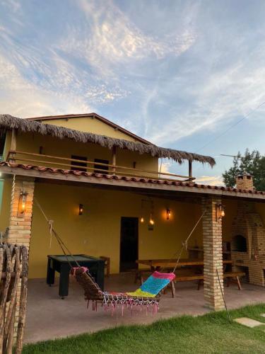 una casa con un patio con sillas y una mesa en Beach House Tijuca, en Itarema