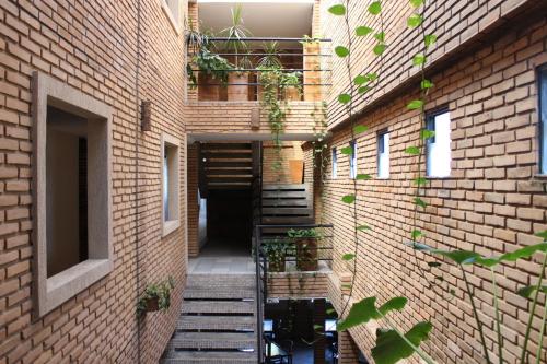 a brick hallway with stairs in a building with plants at Cais da Praia Hotel in Maceió