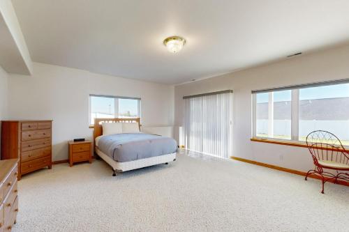 a bedroom with a bed and a dresser and windows at Sunnyside Retreat in Kalispell