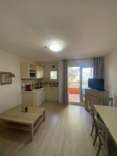 un salon avec une table et une cuisine avec une fenêtre dans l'établissement Charmant studio tout équipé, à Saint-Raphaël