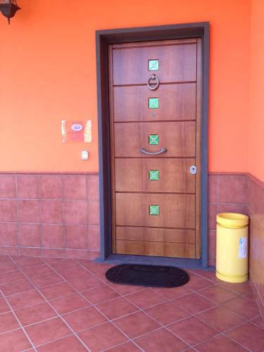 a wooden door in a room with a trash can at Orange Holiday Home in Torvaianica