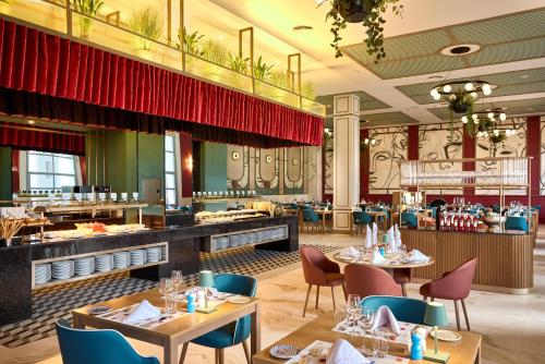 a dining room with tables and chairs and a restaurant at Riu Palace Bavaro - All Inclusive in Punta Cana