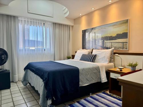 a hotel room with a bed and a painting on the wall at Flat Pasargada 1013 in Vila Velha