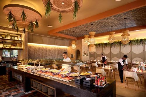 a restaurant with a buffet line with people preparing food at Riu Palace Bavaro - All Inclusive in Punta Cana