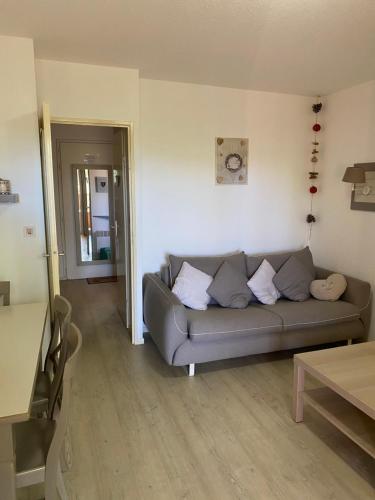 un salon avec un canapé et une table dans l'établissement Charmant studio tout équipé, à Saint-Raphaël